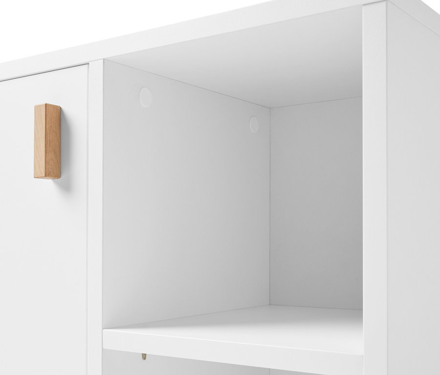 Détail d'un meuble sous-vasque blanc avec porte et compartiment latéral.