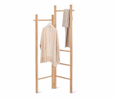 Un pull est suspendu à un cintre sur un porte-vêtements échelle et une écharpe est suspendue à côté.