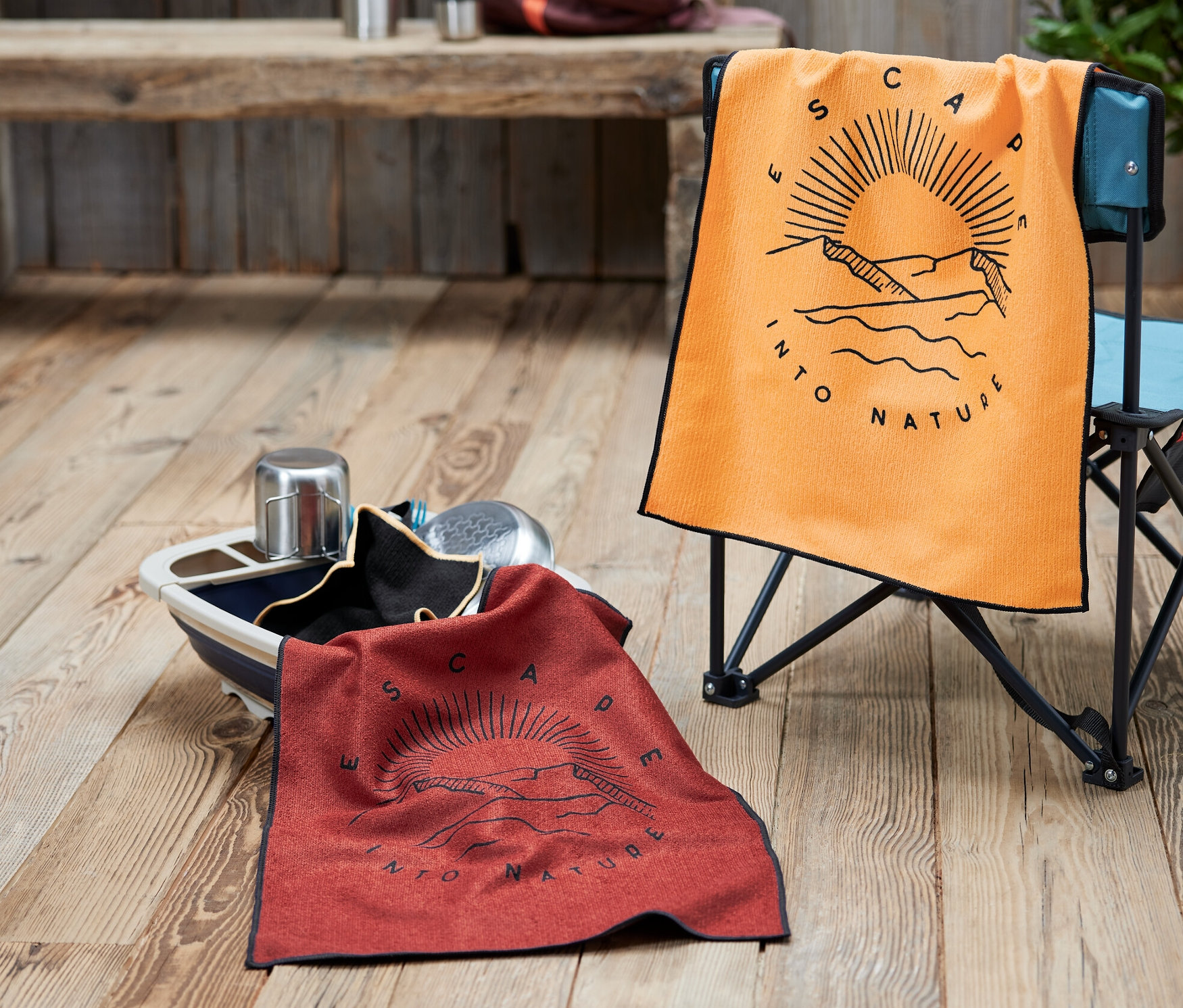 Un torchon à vaisselle orange sur une chaise et un torchon à vaisselle rouge dans un bol. Un sac à dos et une thermos sont à l'arrière-plan.