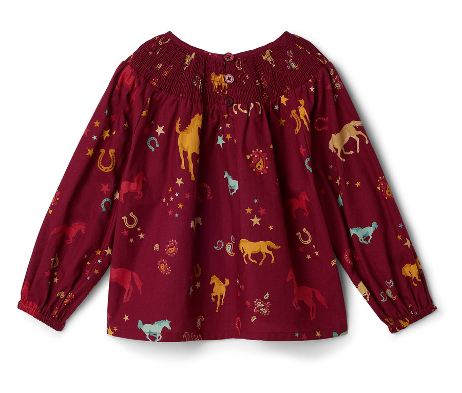 Chemisier bordeaux à manches longues avec des motifs de chevaux, de fers à cheval et d'étoiles.