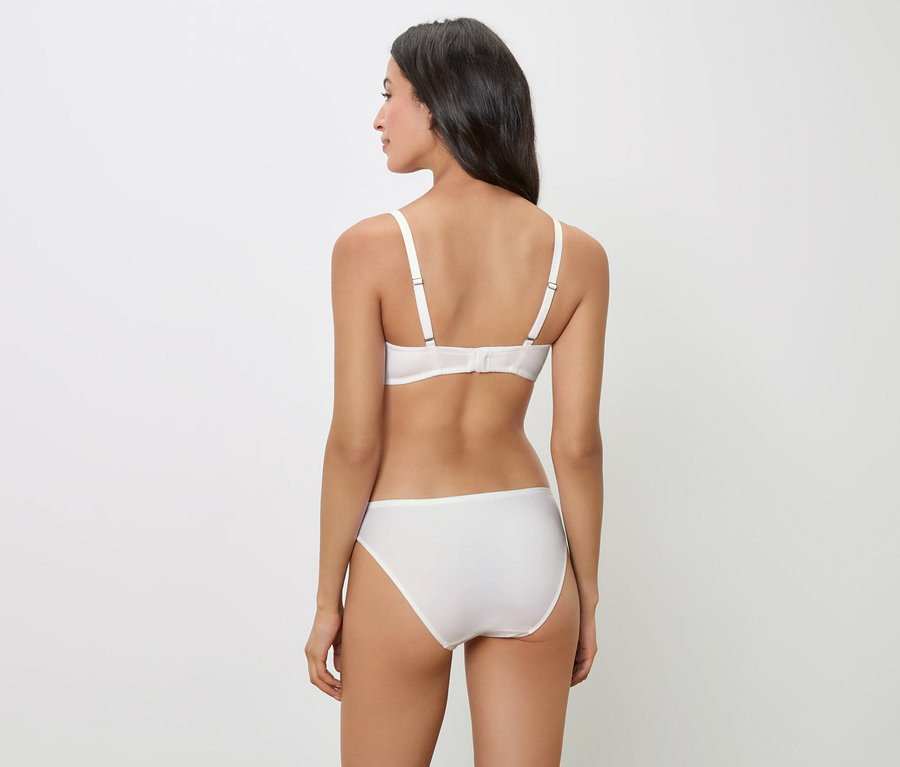 Vue arrière d'une femme aux cheveux foncés portant un soutien-gorge et une culotte blancs.