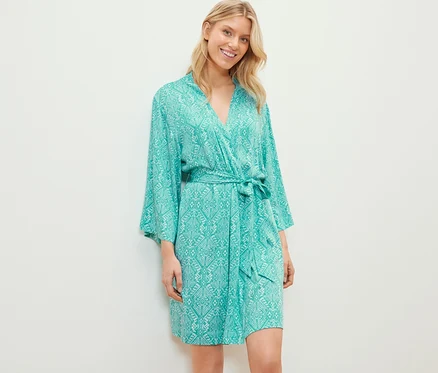 Blonde portant une robe de chambre à motifs floraux.