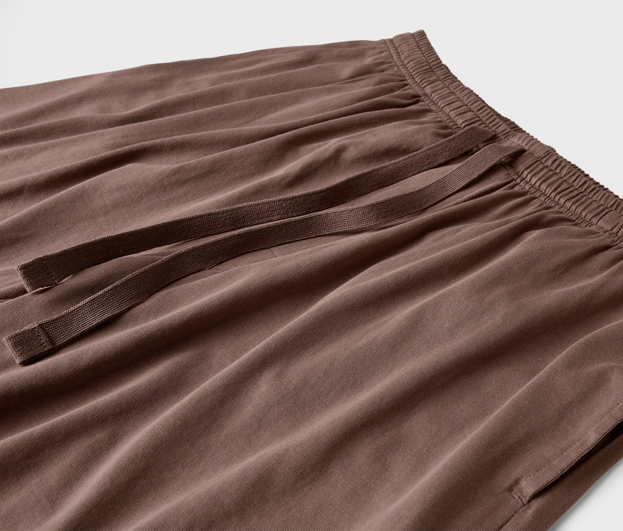 Gros plan sur un pantalon marron avec cordon de serrage et poches.