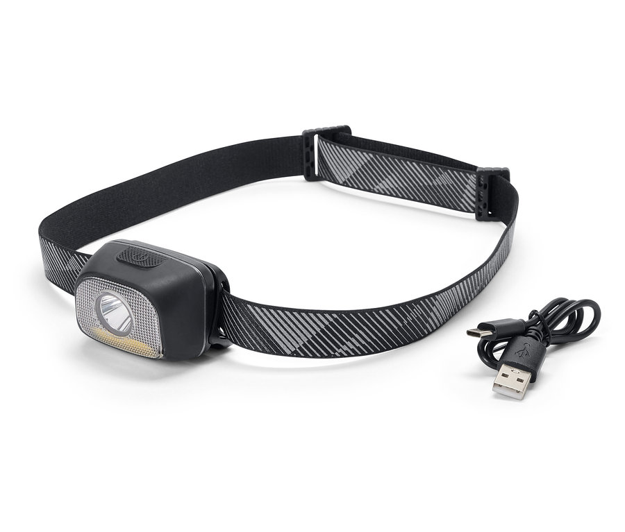 Une lampe frontale noire avec un bandeau à motifs gris et blancs et un câble de chargement USB.