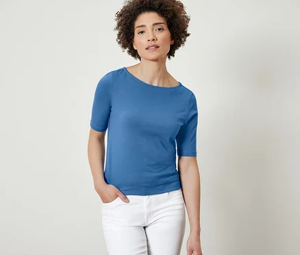 Femme posant dans un t-shirt bleu à manches courtes.