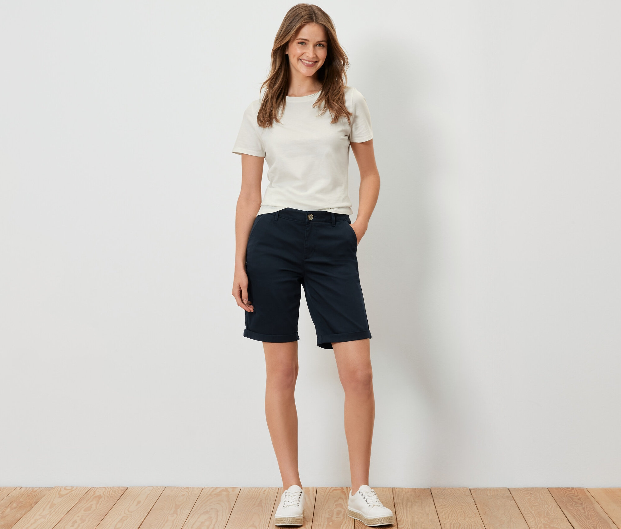 Femme debout portant un short chino bleu marine.