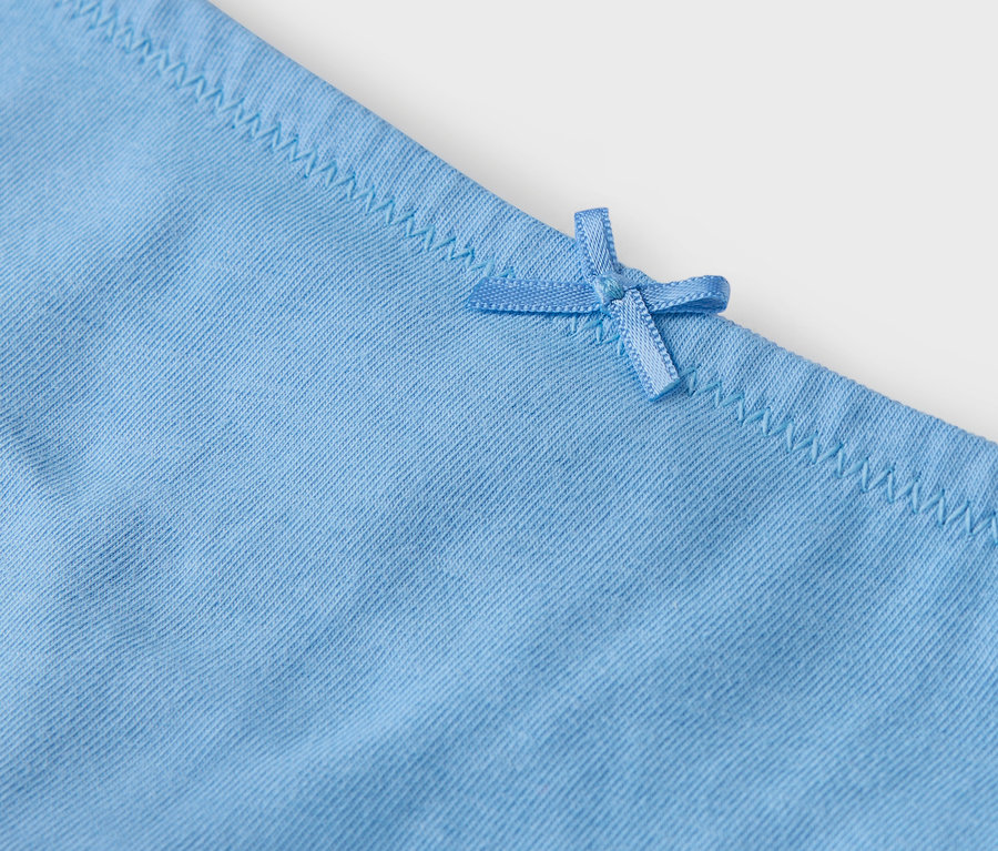 Détail d'une culotte bleu clair avec un nœud.