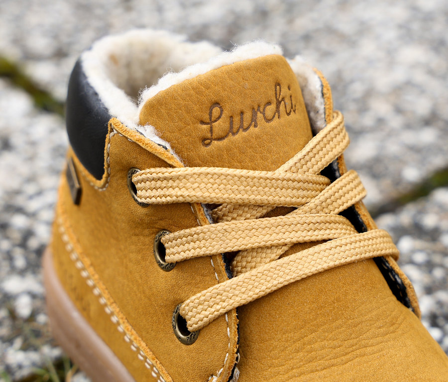 Gros plan d'une chaussure jaune Lurchi « Fleximo Barefoot-TEX » avec des lacets marron.
