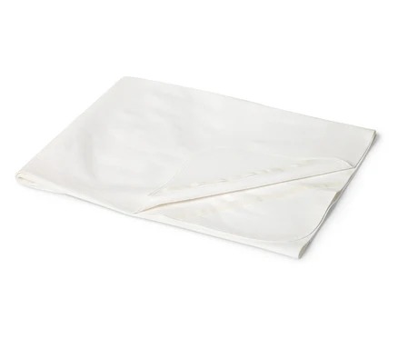 Gros plan sur une couverture de bébé couleur crème pliée.