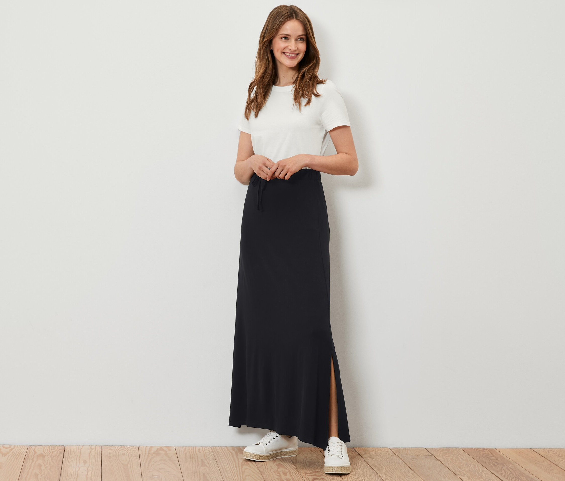 Femme posant en jupe longue noire en jersey.