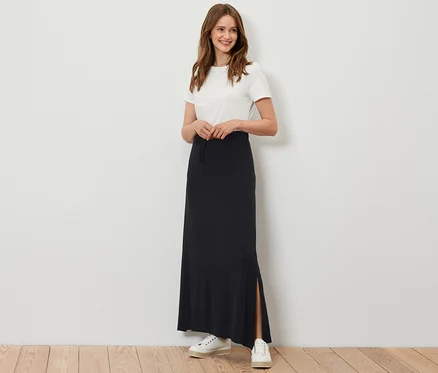 Femme posant en jupe longue noire en jersey.