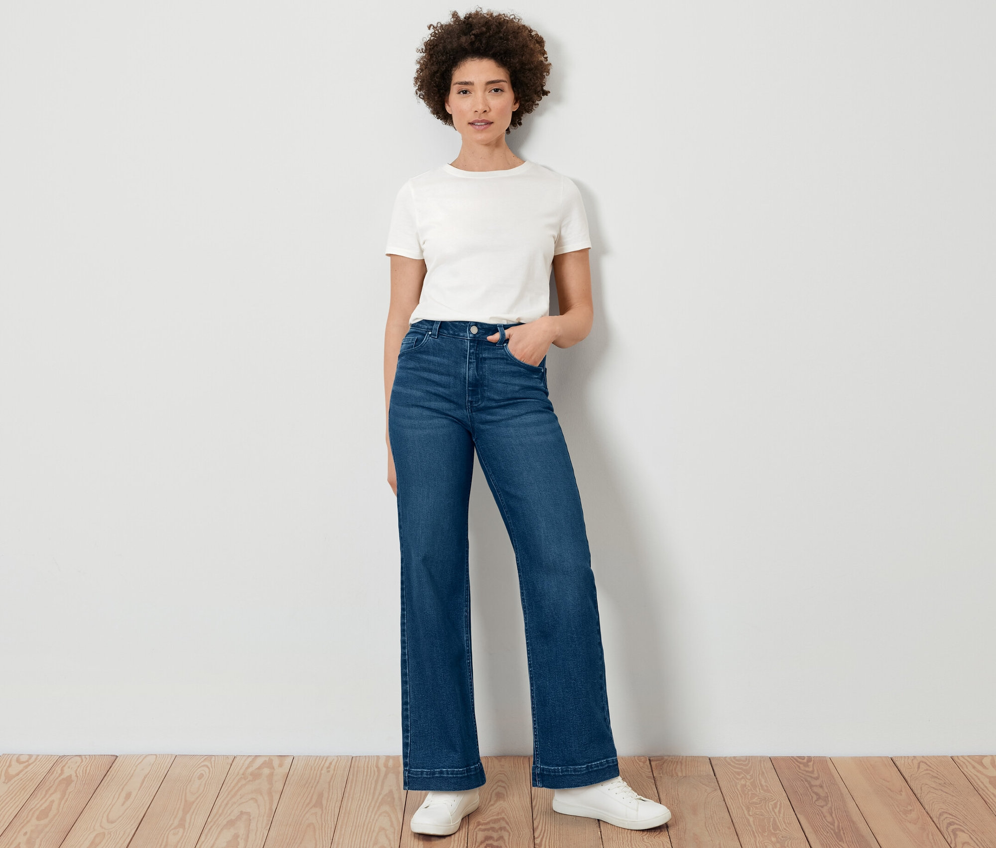Une femme pose en jeans Wide Leg – Fit « Viki » et un t-shirt blanc.