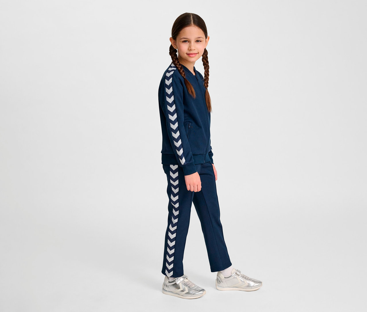 Fillette portant un ensemble bleu avec une veste à fermeture éclair Hummel HMLJR Archive Reg Poly.