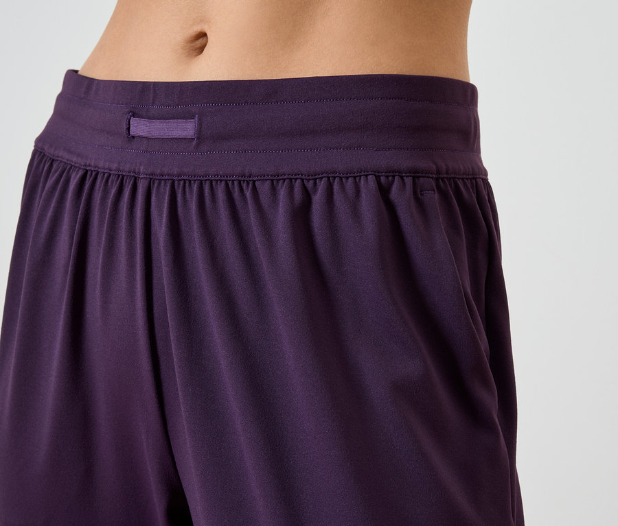Détail d'un pantalon violet pour femme avec taille élastique et poches.