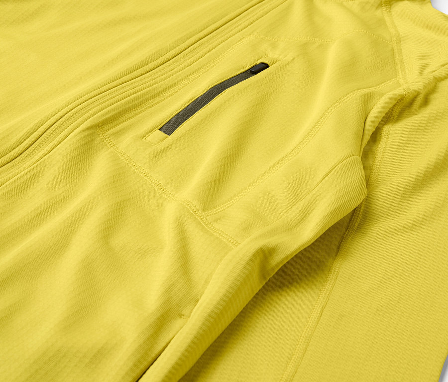 Gros plan sur une veste jaune avec fermeture éclair et poche poitrine.