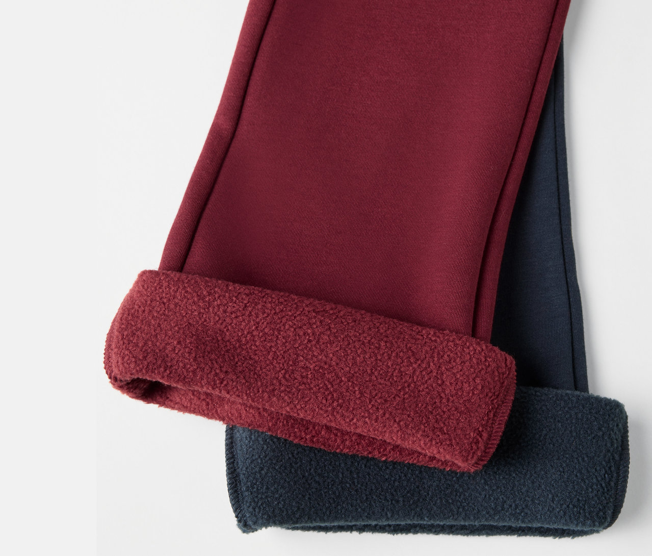 Gros plan sur deux leggings thermiques évasés pour enfants avec intérieur gratté.