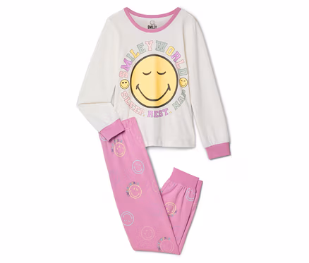 Pyjama pour enfant SMILEYWORLD®: Un haut à manches longues crème avec un grand visage souriant jaune et le texte « SMILEY WORLD SLEEP. REST. NAP. », et un pantalon rose orné de petits smileys pastel.