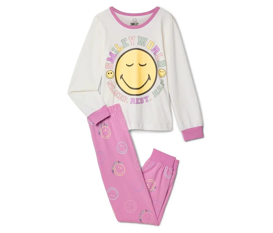 Pyjama pour enfant SMILEYWORLD®: Un haut à manches longues crème avec un grand visage souriant jaune et le texte « SMILEY WORLD SLEEP. REST. NAP. », et un pantalon rose orné de petits smileys pastel.