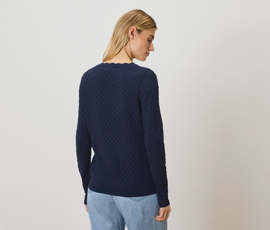 Femme portant un pull bleu marine et un jean.