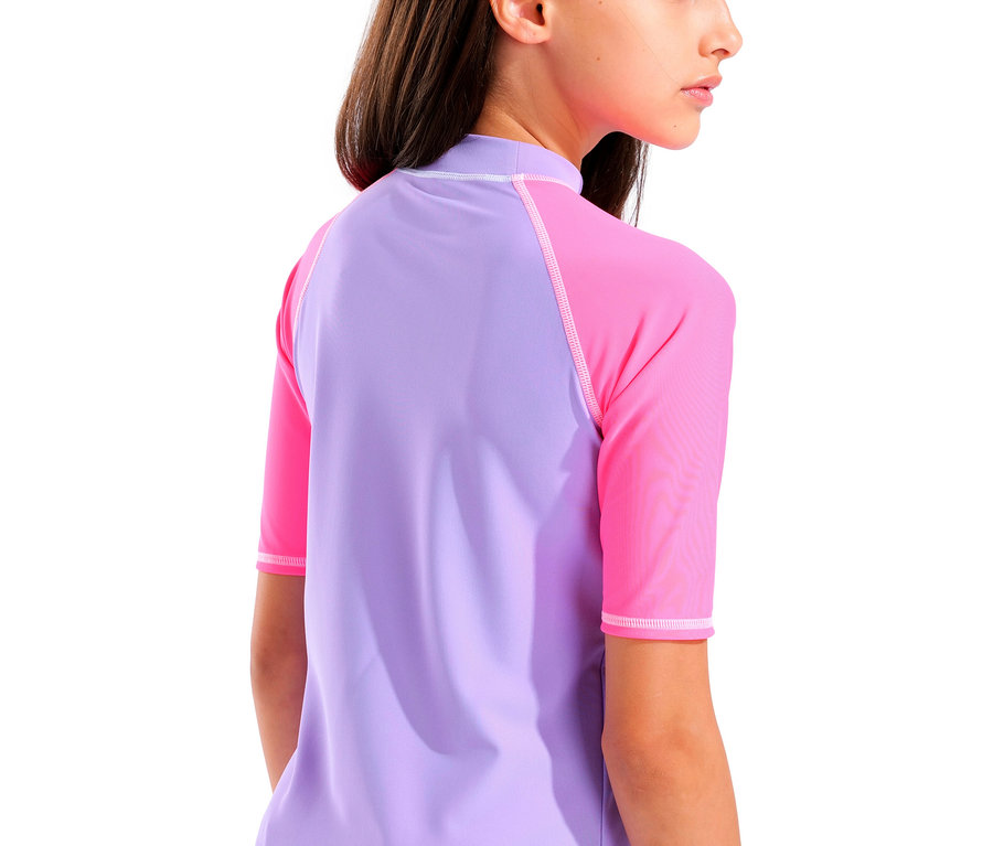 Gros plan d'une jeune fille portant un rashguard lilas et rose à manches courtes.