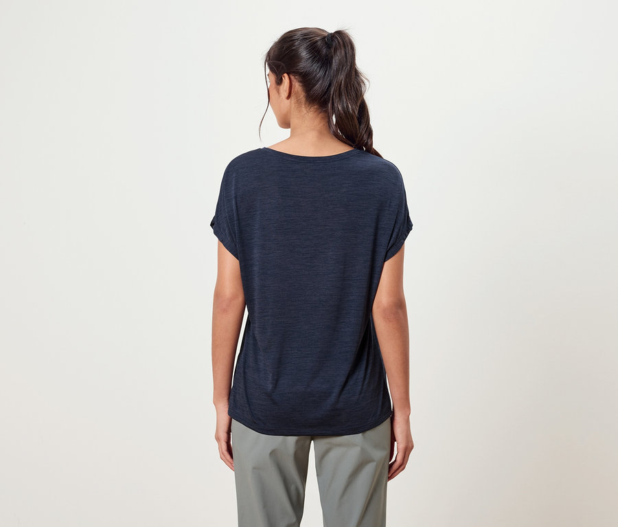 Vue de dos d'une femme avec une queue de cheval portant un t-shirt bleu marine et un pantalon gris.