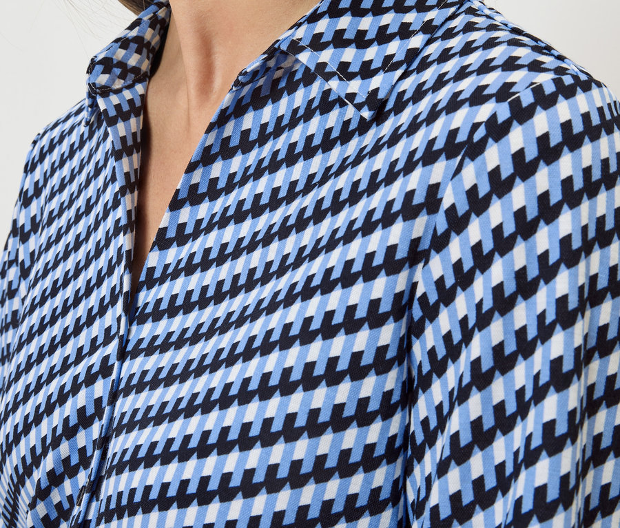 Gros plan d'une chemise à motif géométrique bleu, noir et blanc.