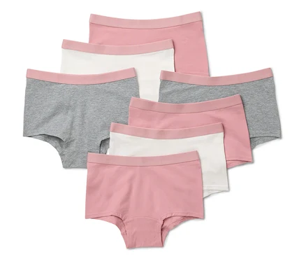 Sept culottes de filles rose fané sont posées sur un fond blanc.