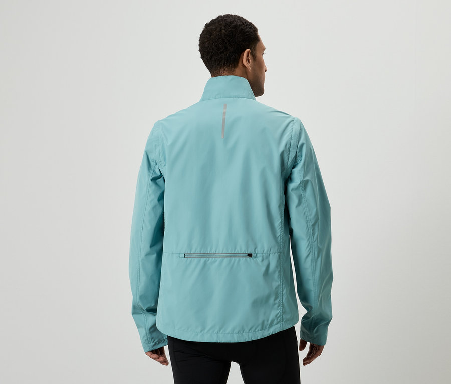 Vue arrière d'un homme portant une veste bleu clair et un pantalon noir sur un fond blanc.