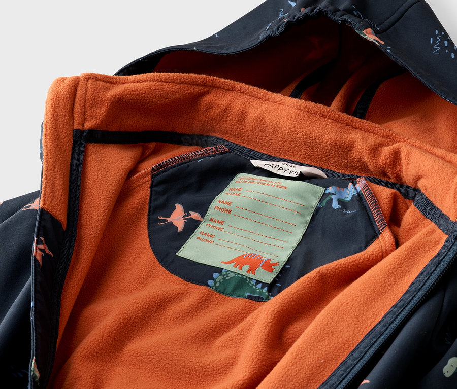 Gros plan d'une veste ouverte pour enfant bleu marine avec motif de dinosaures et doublure polaire orange.