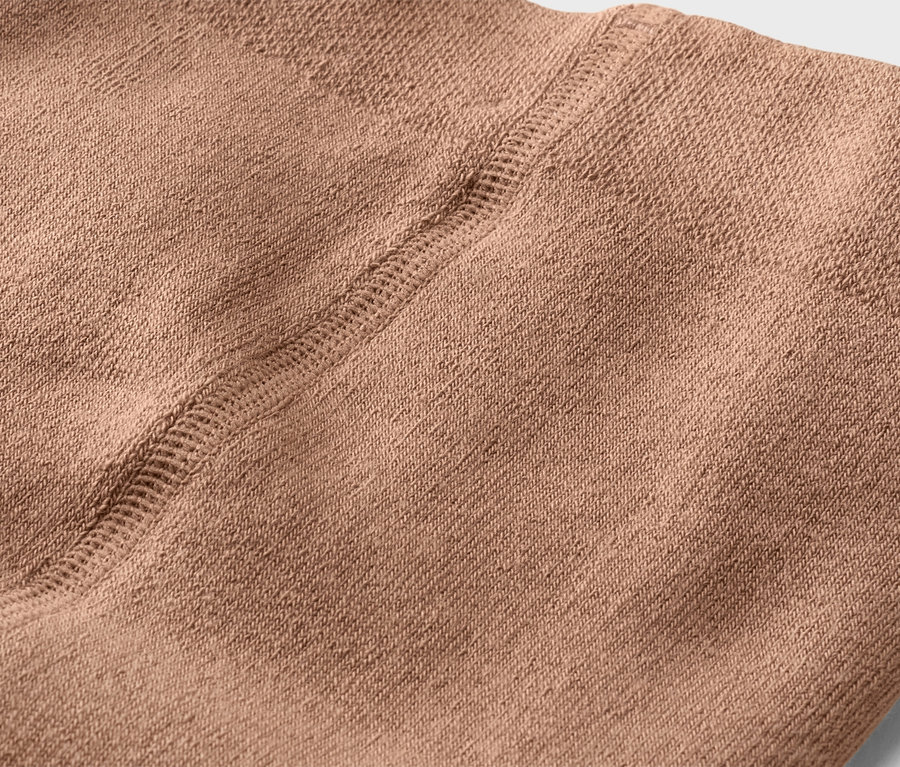 Gros plan sur un tissu beige avec une couture.