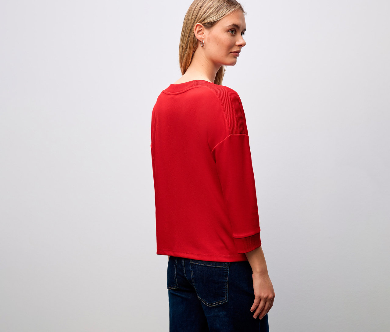 Femme portant un t-shirt rouge Street One avec des détails côtelés et un jean.