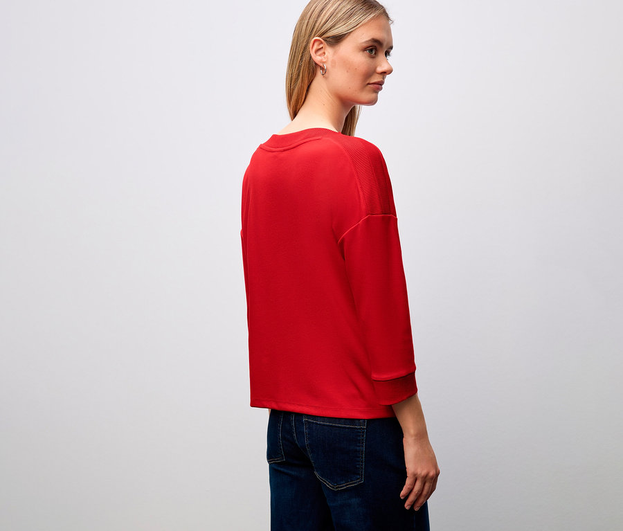 Femme portant un t-shirt rouge Street One avec des détails côtelés et un jean.