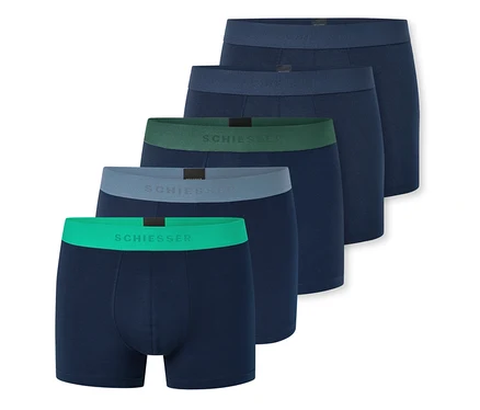 Cinq boxers bleu foncé sont étalés en éventail, chacun avec une ceinture de couleur différente : vert vif, gris clair, vert foncé et deux bleu foncé. "SCHIESSER" est visible sur les trois premières ceintures.