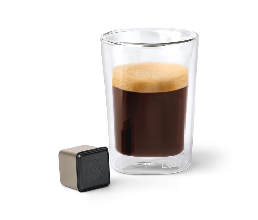 Café dans un verre transparent à côté d'une capsule Qbo Caffè.