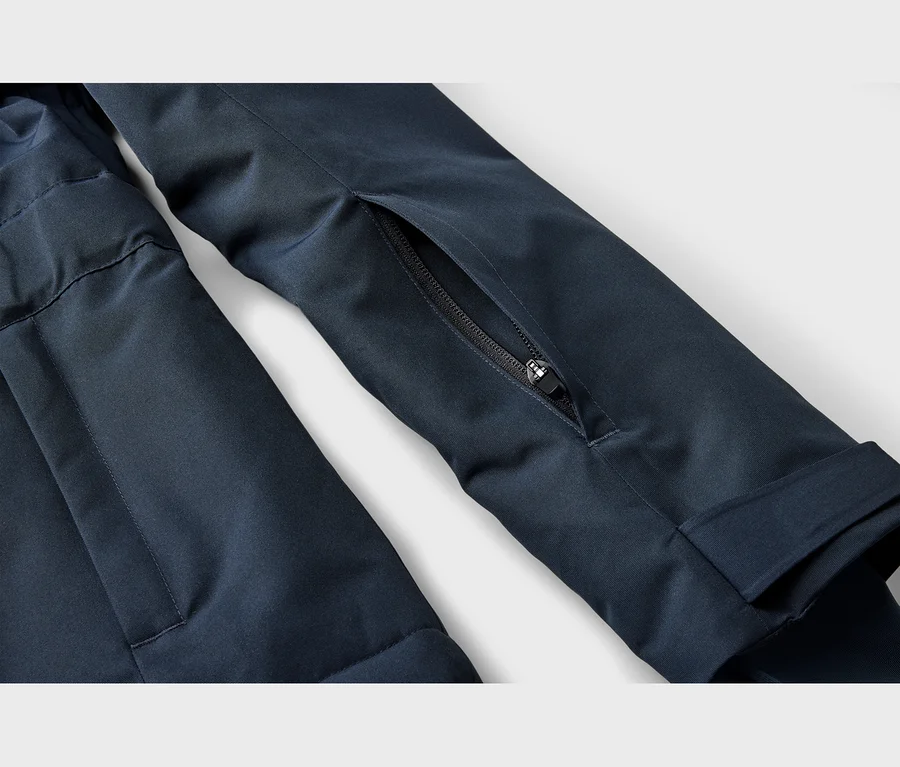 Gros plan sur la manche d'une veste bleu foncé avec une poche zippée partiellement ouverte.