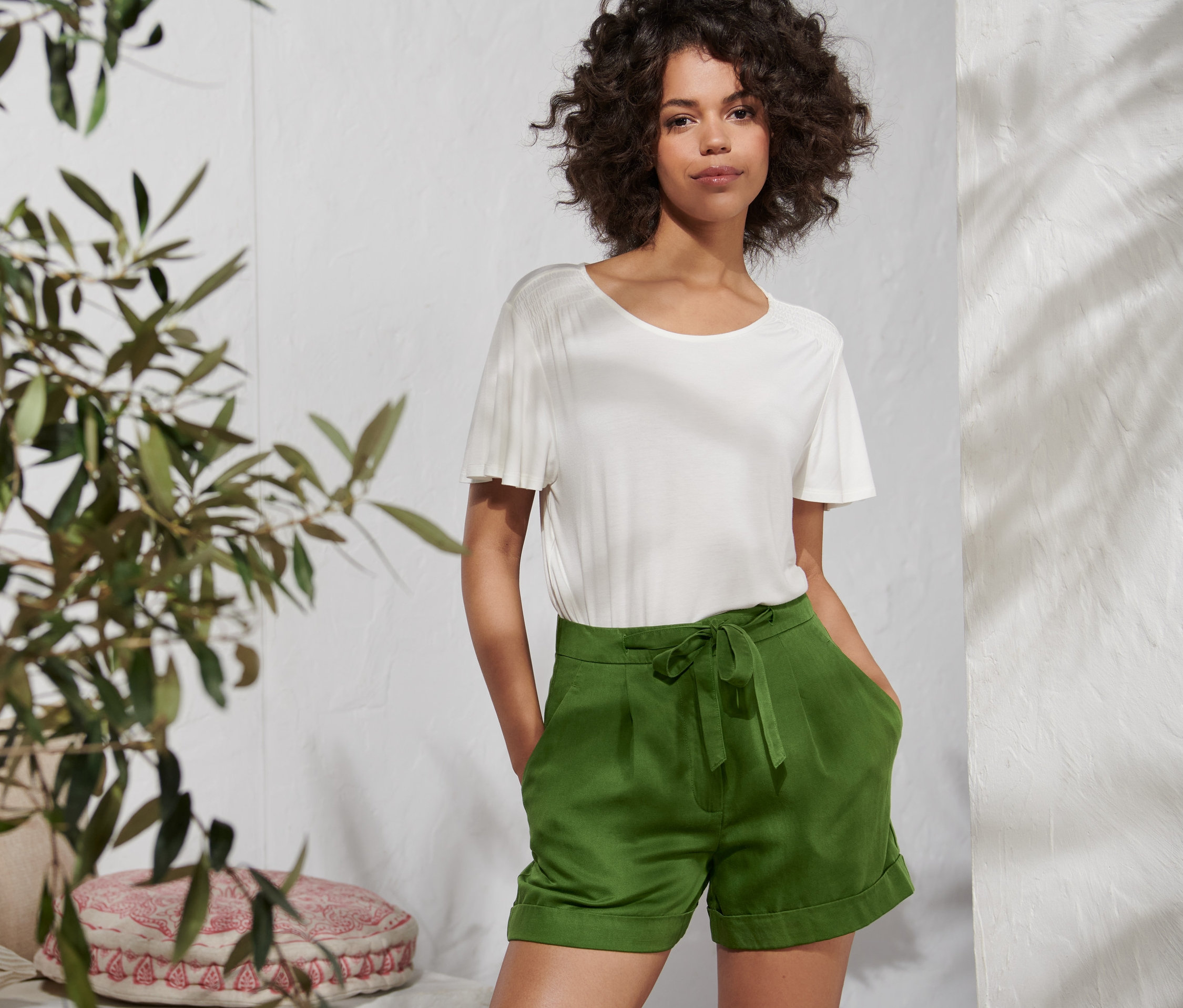 Femme posant en short vert en mélange de lin.