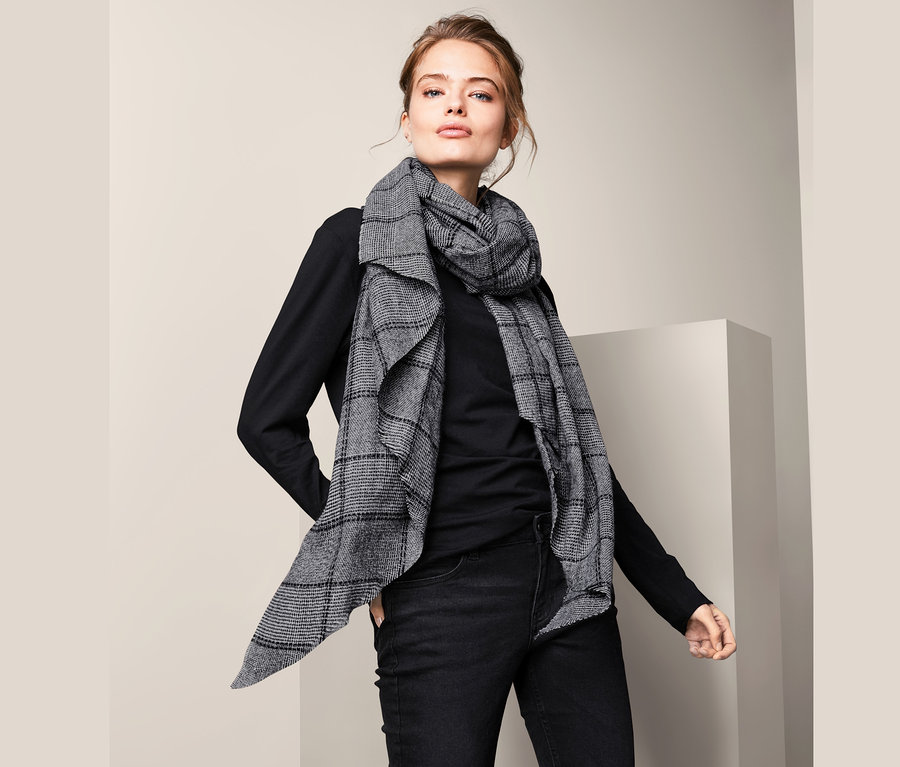 Femme posant avec une écharpe tissée XXL.