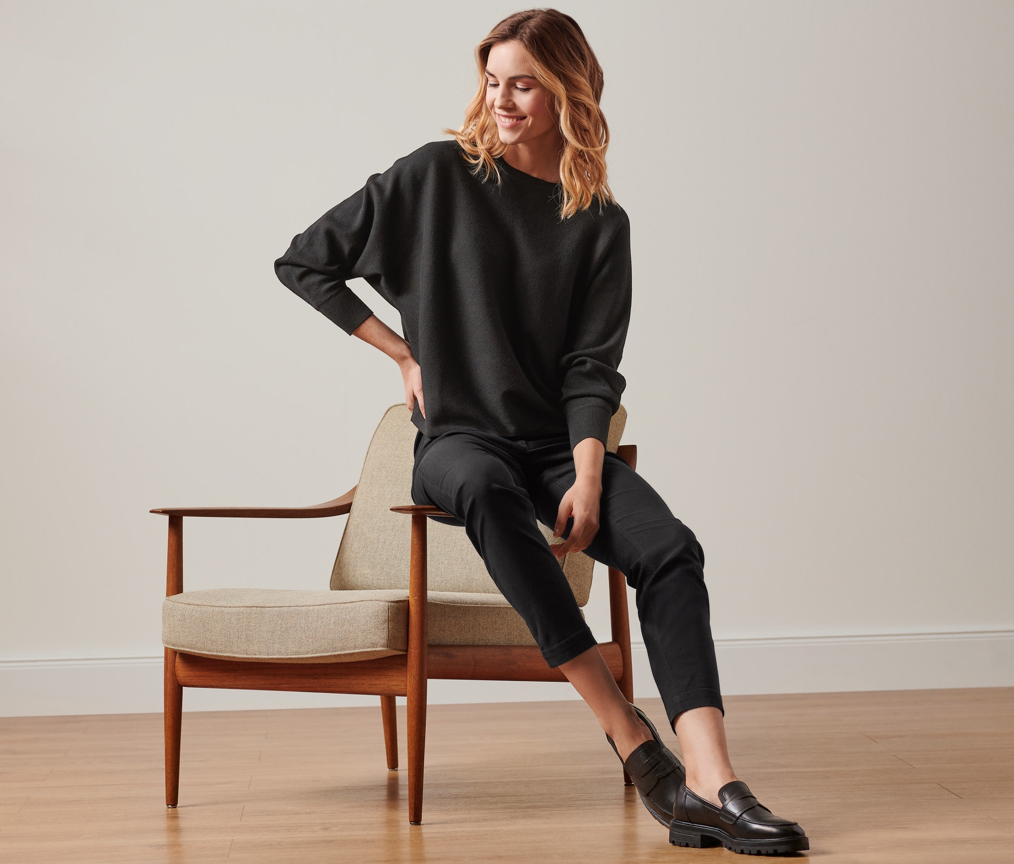 Une femme est assise sur une chaise et porte un pantalon prêt à porter en bengaline noir.
