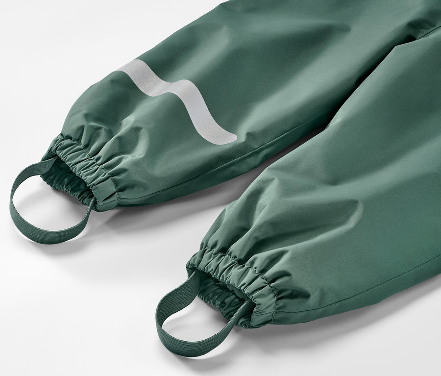 Détail d'un pantalon de pluie thermique pour enfant, vert foncé.