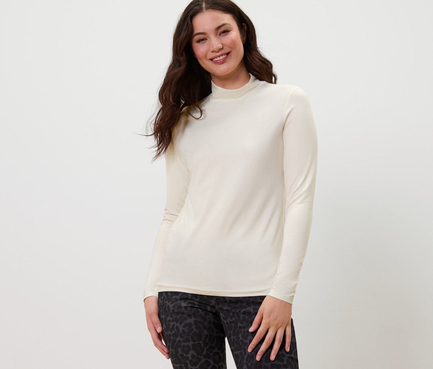 Femme posant en blouse à col montant et pantalon à motifs.