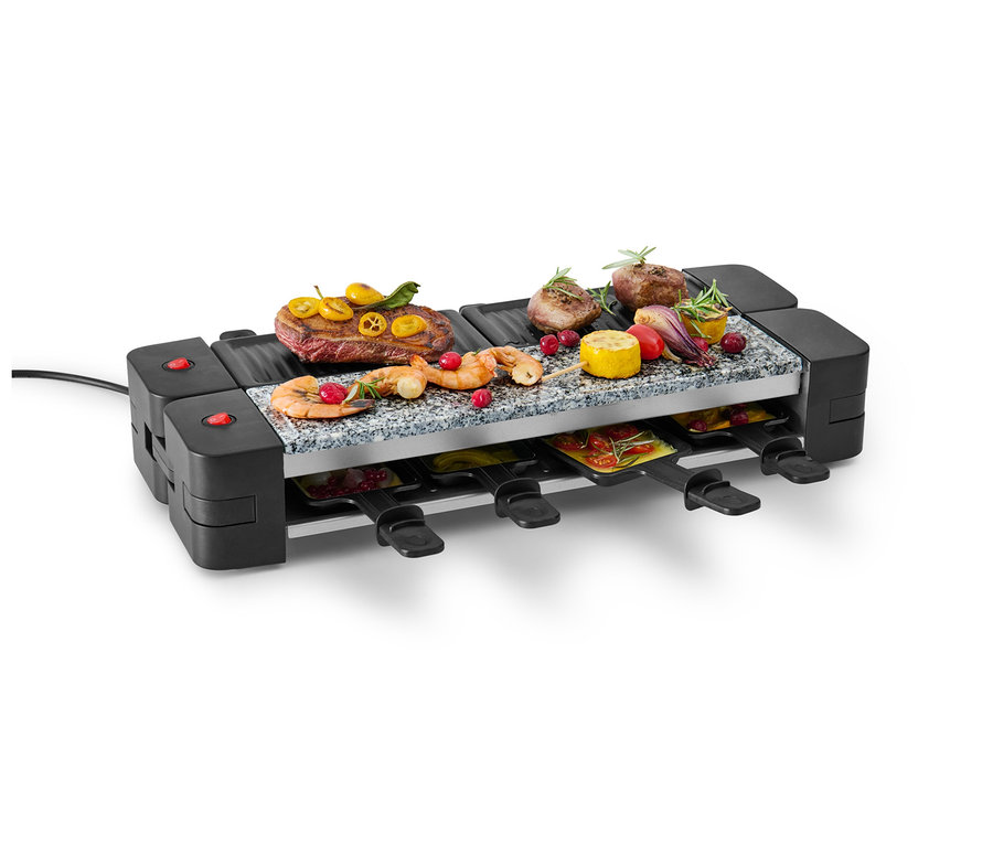 Un appareil à raclette pliable avec de la viande, des crevettes et des légumes sur le dessus et des poêles en dessous.