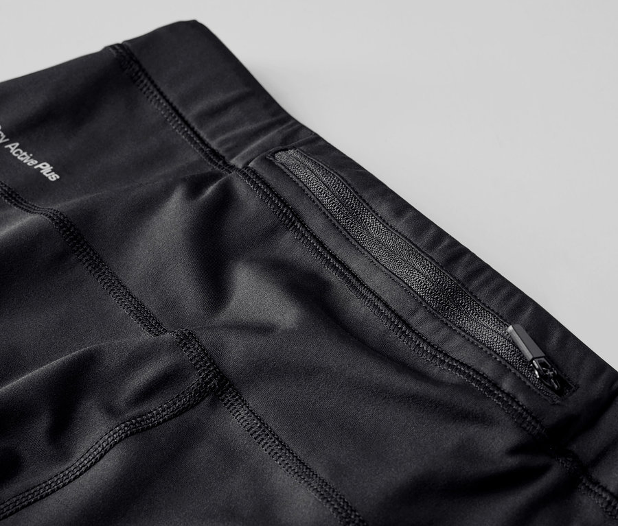 Gros plan sur un legging de sport noir avec une poche zippée et l'inscription Dry Active Plus.