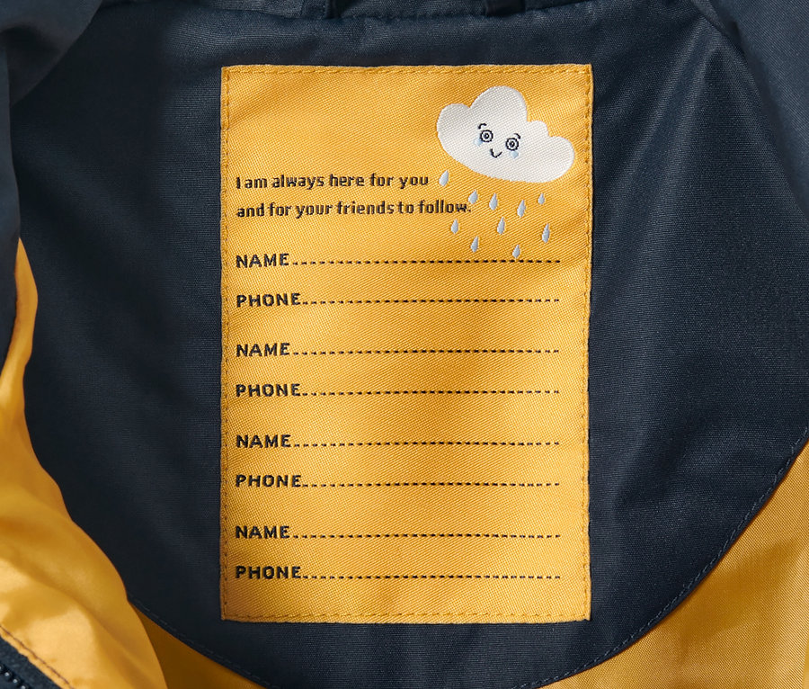 Intérieur d'une une-pièce imperméable pour tout petit avec étiquette pour le nom et le numéro de téléphone.