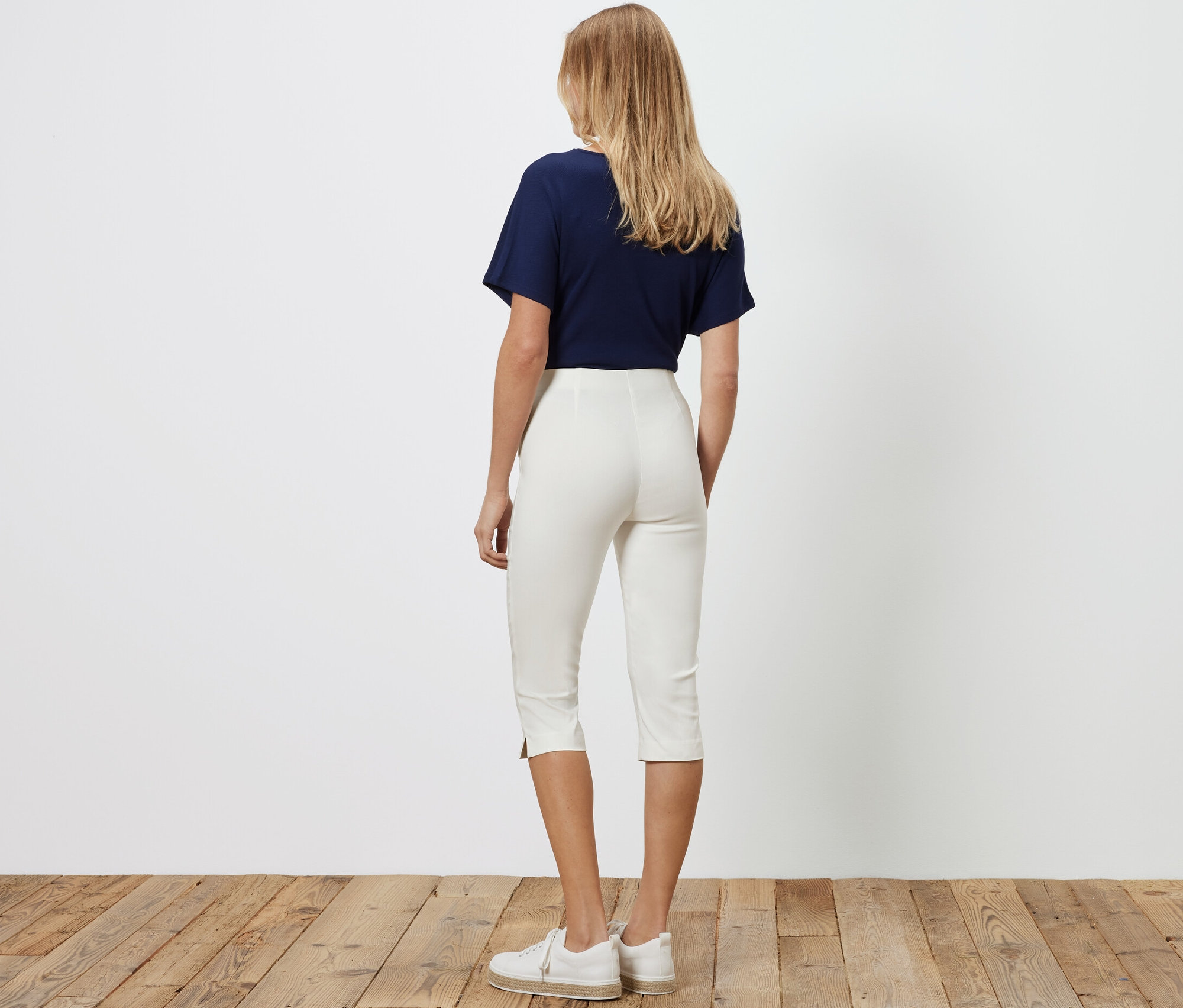 Femme vue de dos portant un pantalon 3/4 stretch blanc.