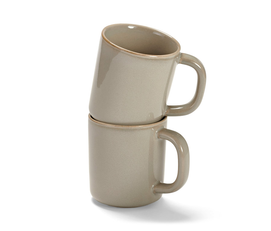 Deux tasses beiges empilées l'une sur l'autre.