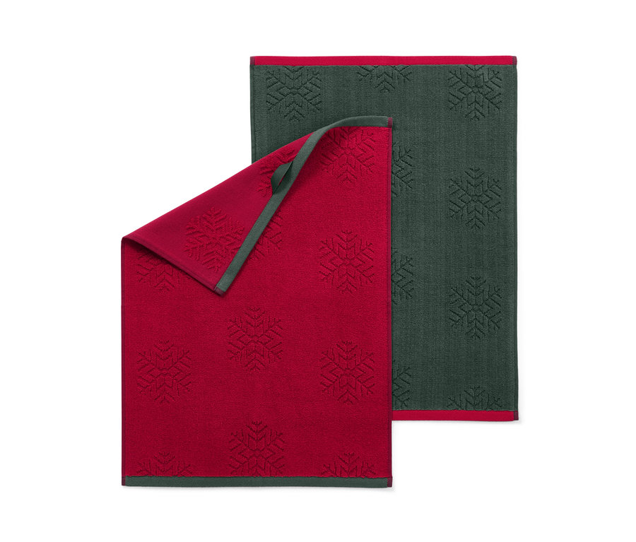 Deux linges de cuisine avec motif de flocons de neige, un rouge et un vert foncé.