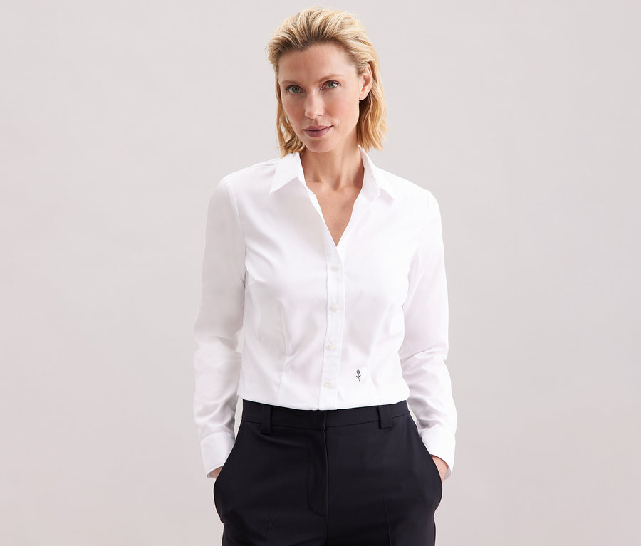 Femme portant un chemisier blanc Slim Fit non iron Seidensticker.