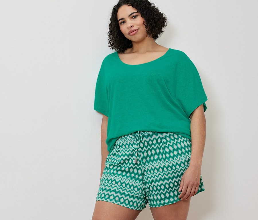 Une femme porte un t-shirt en lin mélangé aqua et 2 shorts en jersey.