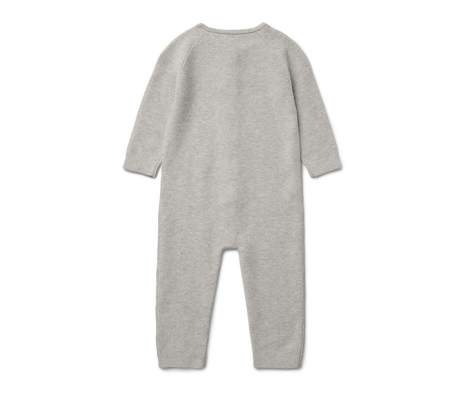 Une combinaison en maille grise pour bébé est posée sur un fond blanc.