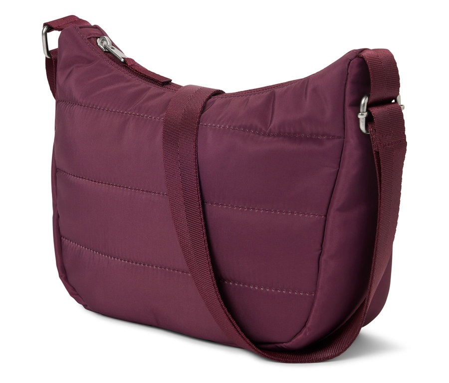Un sac à main matelassé bordeaux avec une bandoulière réglable posé sur un fond blanc.